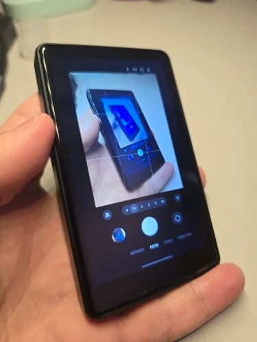 Poza unui client: monitorul SelfiePro pornit, ținut în mână